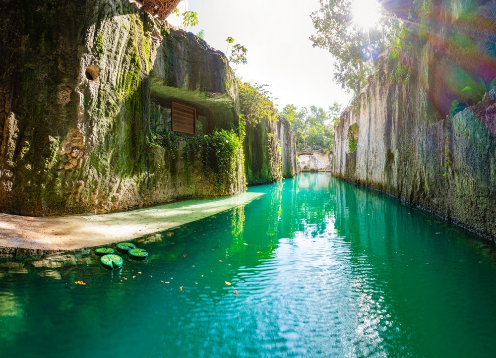 A photo of a beautiful waterway, featuring mossy cliffs and turquoise waters.