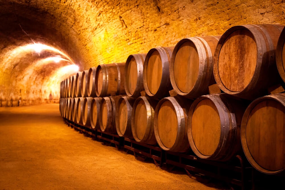 Bodega: An indoor wine cellar with rows of wooden barrels