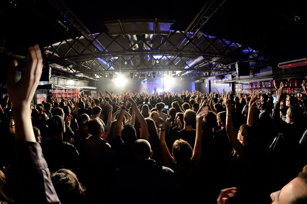 Barcelona nightlife: A crowd of people dancing to a concert in a nightclub