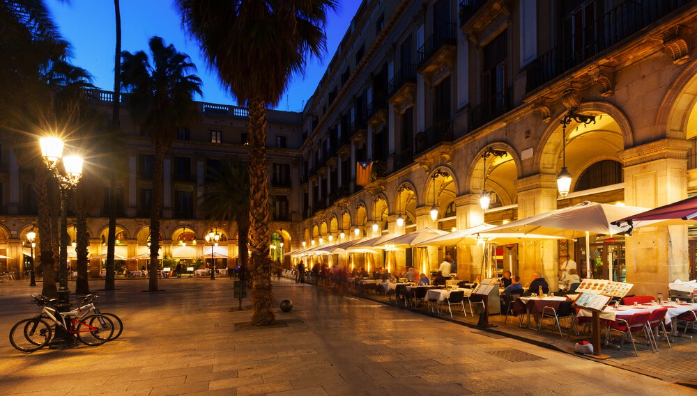 Gothic Quarter: A view of a plaza surrounded by a building with arches lit up