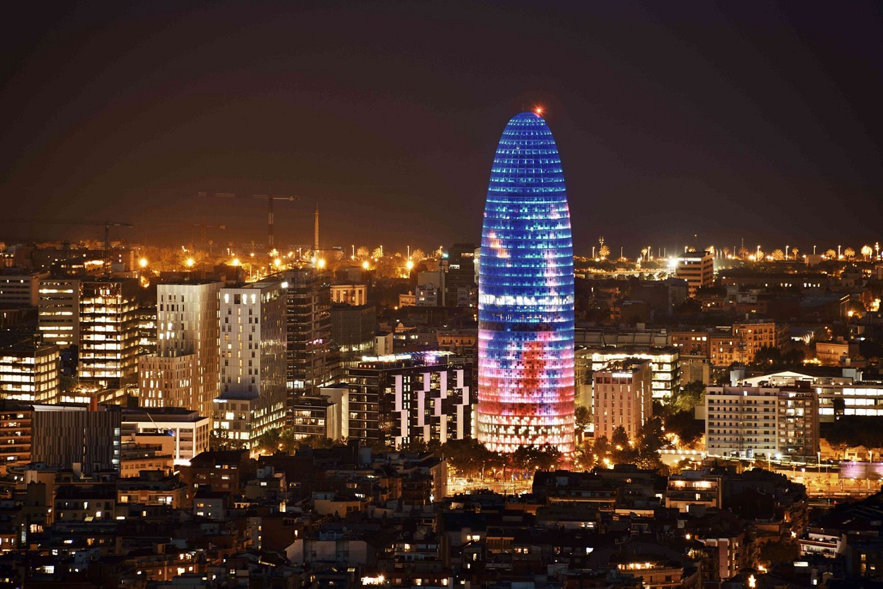 Barcelona nightlife: Barcelona skyline lit up at night with a view of the Torre Glòries