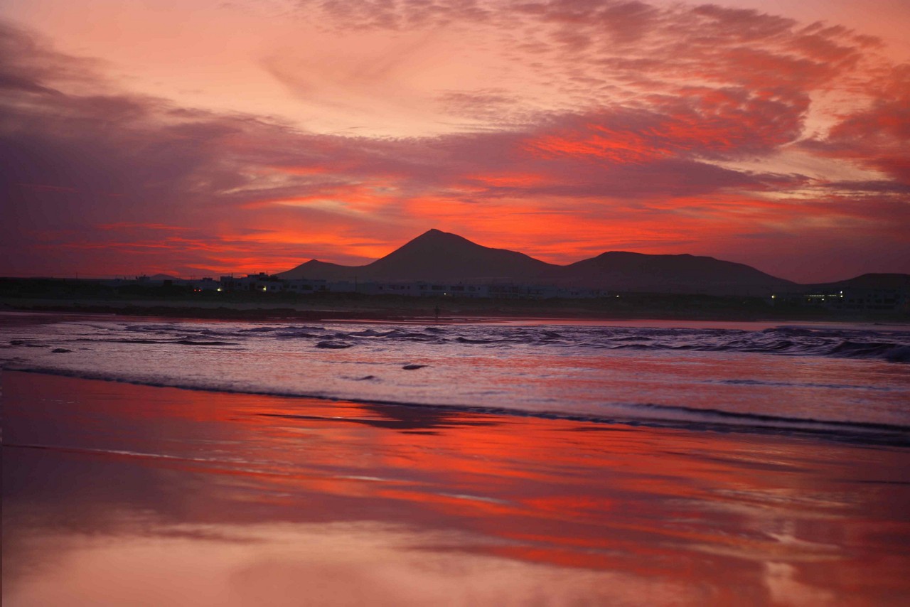 Lanzarote nightlife: Red sunset over the volcano and the ocean in Lanzarote