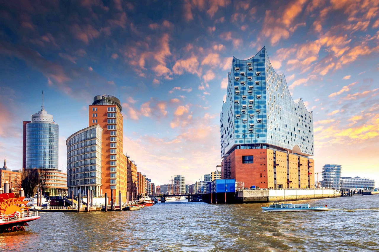 Things to do in Hamburg: A view of tall, modern, glass and brick buildings by the riverside