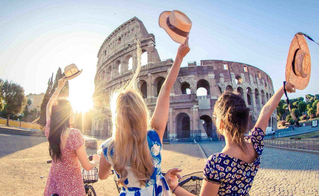 Girls’ trip ideas: Photo of three girls, backs to the camera in front of the Colosseum