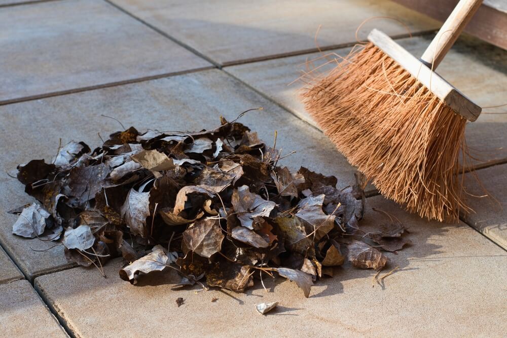 Latin American New Year’s traditions: Someone sweeping a pile of brown leaves