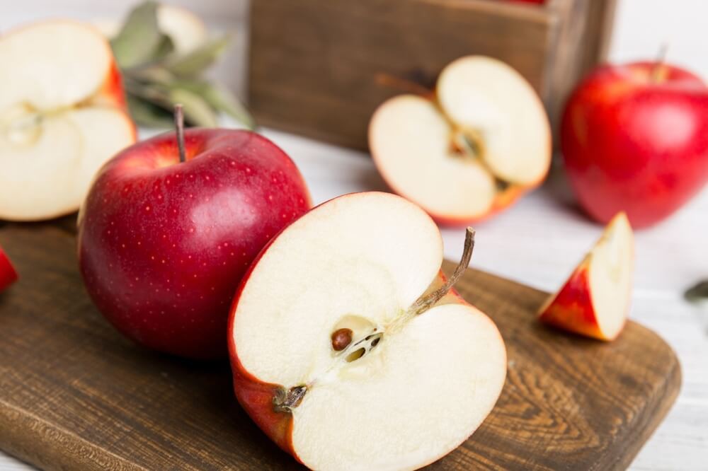 Czech Apples: A brown wooden board with red cut apples on top