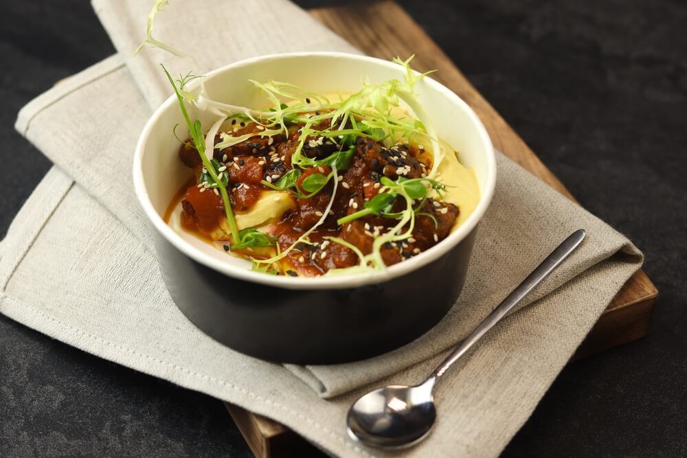 Goulash: A black pot with pork goulash inside garnished with a green leaf