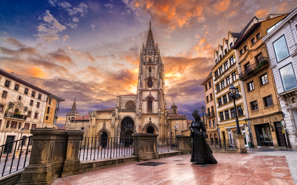 Things to do in Oviedo: Views of Oviedo Cathedral and statue at sunset from across the square