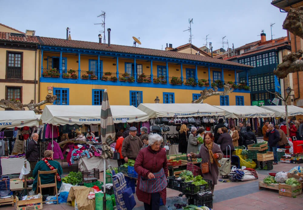 Fontán Square Market: A market square surrounded by yellow buildings with a busy market taking place 