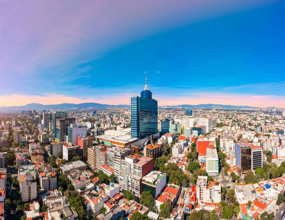 A bird’s eye view of Mexico City, with a clear blue sky in the background. 