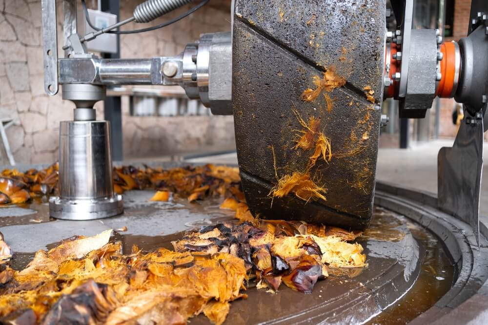 Best tequila in Mexico: A roller crushing cooked agave in a tequila factory