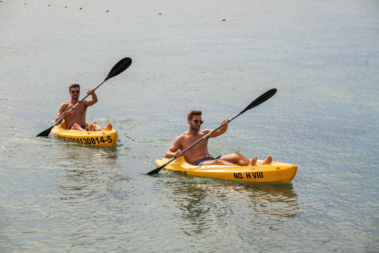 Two men kayaking during a fitness vacation.