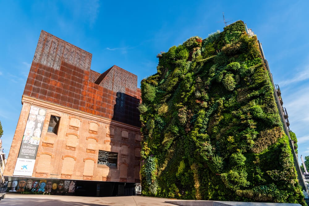 Caixaforum: Red modern building next to a green living wall