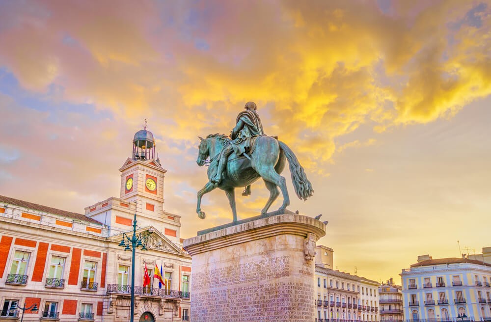 Sehenswürdigkeiten in Madrid: Puerta del Sol mit Reiterstandbild in der Dämmerung.