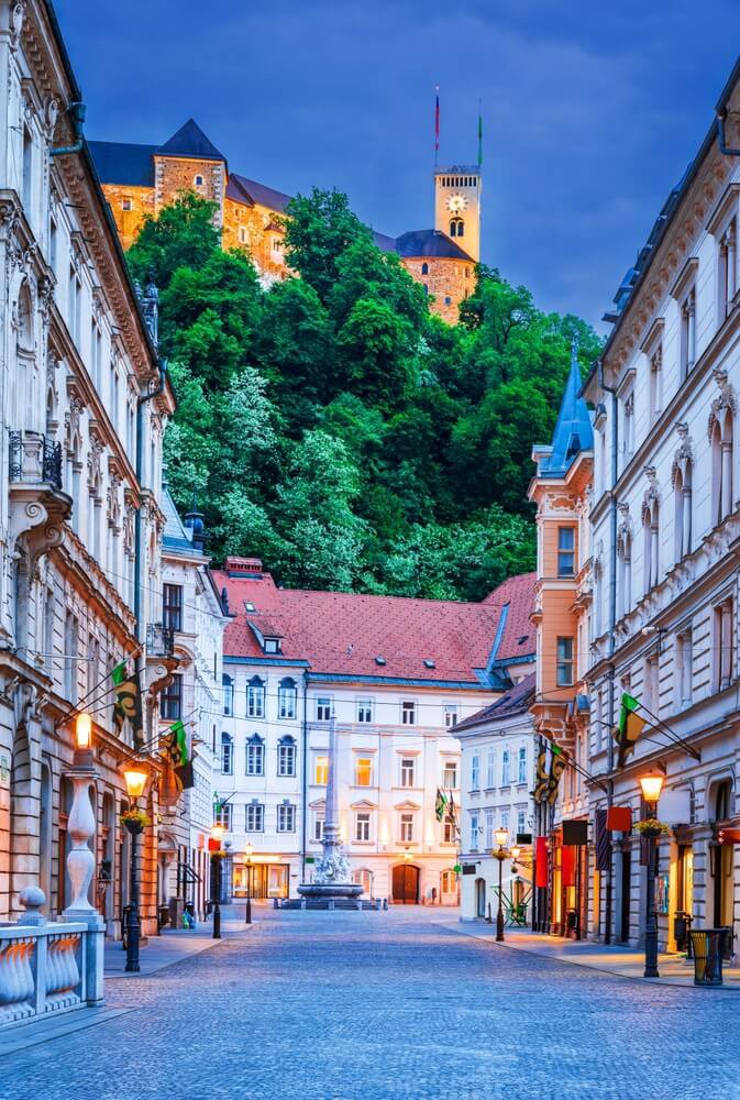 Best holidays for teenagers: A typical Ljubljana street lit up at night with mountains