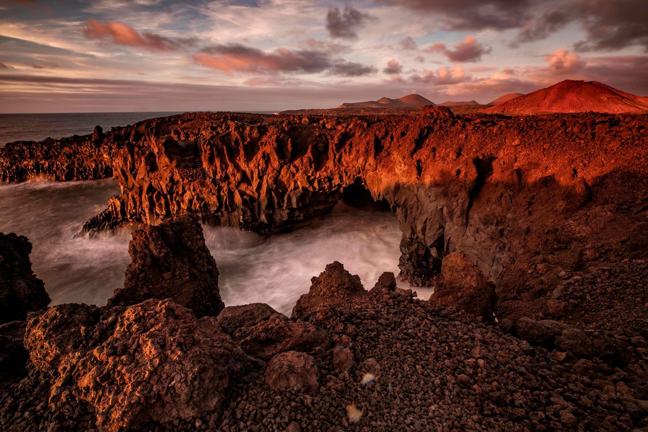 Things to do in Lanzarote: Red sunset with mountains in the background